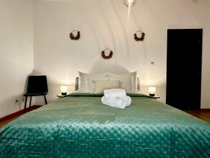a bedroom with a green bed with two towels on it at Luxury Suites Stay by Rikas Hotels in Antwerp
