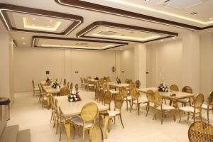 a banquet hall with tables and chairs in a room at The Meera Hotel in Ujjain