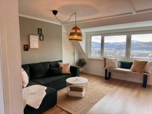 a living room with a green couch and a table at Dat Höhnerstübche Apartment in Siegen