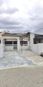 a white fence in front of a white house at CikSiti homestay02 in Kajang