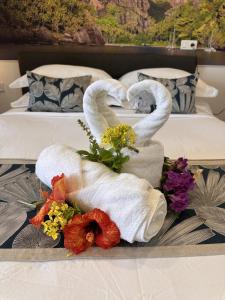 two swans made out of towels on a bed at Ononui Lodge Airport, Ocean-View, Private Bathroom and Balcony, Free WiFi and Parking, On-Site Car Rental in Faaa