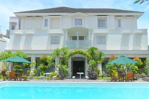 a hotel with a swimming pool in front of a building at KAWANA HOTEL in Kampungdurian