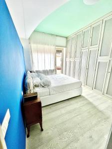 una camera da letto con un letto e una parete blu di Ci ASpettA Lorenzo a Roma