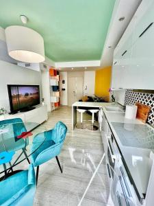 una cucina con sedie blu e un tavolo in una stanza di Ci ASpettA Lorenzo a Roma