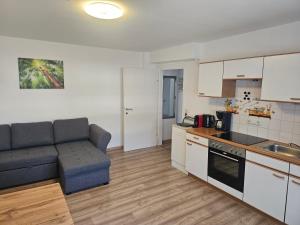 a living room with a couch and a kitchen at Ferienwohnung Melissa in Unter Feuchten