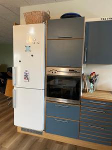 a kitchen with a refrigerator and a stove at Højmosegård værelse 4 in Varde