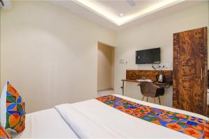 a bedroom with a bed and a table and a television at FabHotel The Hastings Club - Nr Victoria Memorial in Kolkata