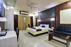 a hotel room with a bed and a desk at Hotel Devanshi & Banquets by Classy Stay in Navi Mumbai