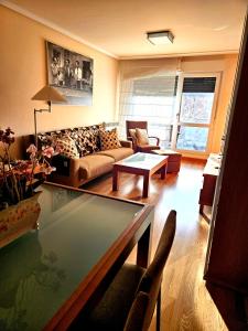 a living room with a couch and a table at Red Wine Haro, piscina y parking in Haro