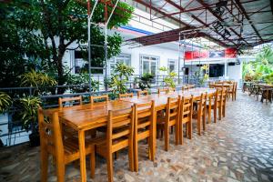 a long wooden table and chairs in a restaurant at RedDoorz at Lao Singuan Homestay in Del Carmen