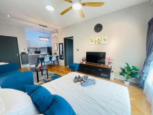 a living room with a blue couch and a tv at Emira Residence by AisyieraLodgestay in Shah Alam