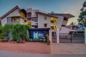 een groot wit gebouw met een bord ervoor bij Hotel Xec Residency in Madgaon