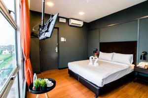a bedroom with a bed and a flat screen tv at Jenjarom Boutique Hotel in Banting