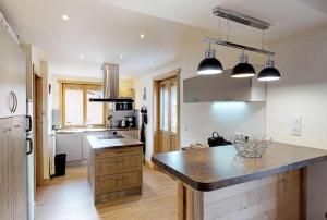 een keuken met een groot kookeiland in het midden bij Chalet De Manou - Chalet individuel rénové avec sauna dans les 3 Vallées MAE-3694 in Saint-Martin-de-Belleville