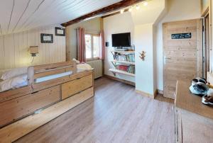 een slaapkamer met een groot bed en een tv bij Chalet De Manou - Chalet individuel rénové avec sauna dans les 3 Vallées MAE-3694 in Saint-Martin-de-Belleville