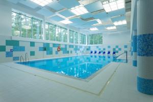 - une grande piscine revêtue de carrelage bleu et blanc dans l'établissement Best Western Hotel Jurata, à Jurata