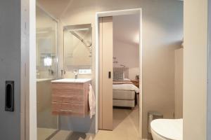 a bathroom with a sink and a toilet and a mirror at Rustig Tiny House in het groen nabij Enschede & UT in Enschede