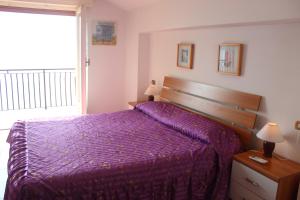 ヴァレンナにあるBellavista garden and flowersのベッドルーム(紫色のベッド1台、窓付)