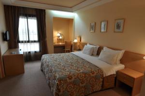 una camera d'albergo con un grande letto e una scrivania di Hôtel Wassim a Fes