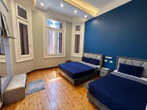 ein Schlafzimmer mit 2 Betten und einer blauen Wand in der Unterkunft Cairo Hub in Kairo