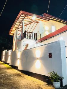 a white house with lights on the side of it at Villa Nevya in Weligama