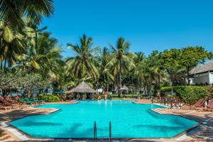 a swimming pool at a resort with palm trees at Serena Beach Resort & Spa in Mombasa