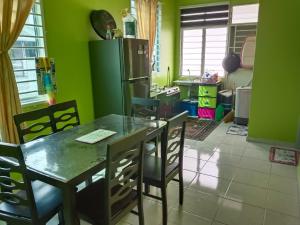 a kitchen with a table and chairs and a refrigerator at NF Residents 2 in Alor Setar