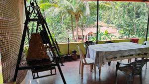 a room with a table and chairs and a large window at Christa Homestay in Mangalore