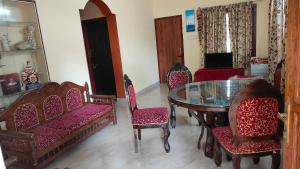 a dining room with a glass table and chairs at Christa Homestay in Mangalore
