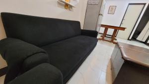 a black couch sitting in a living room at Cozy Casa in the City Center in Baguio +16 photos