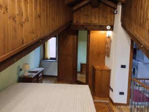 an attic bedroom with a bed and wooden walls at Comodità a due passi dal lago in Verbania