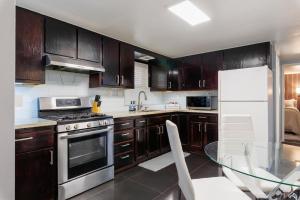 a kitchen with wooden cabinets and a glass table at Victorian Retreat 2Bed, 1Bath, Parking, Game Room in Oakland