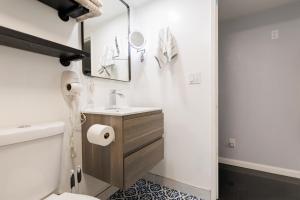 a white bathroom with a sink and a toilet at Victorian Retreat 2Bed, 1Bath, Parking, Game Room in Oakland +27 photos