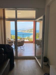 a living room with a glass door leading to a balcony at Apart Bella Utjeha Sea View 68 qm in Utjeha