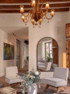 a living room with a chandelier and a mirror at Es Petit de Valldemossa in Valldemossa