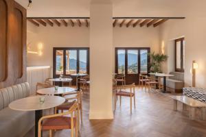 a restaurant with tables and chairs and windows at Es Petit de Valldemossa in Valldemossa