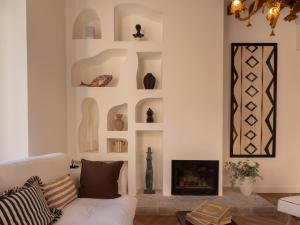 a living room with a white couch and a fireplace at Es Petit de Valldemossa in Valldemossa