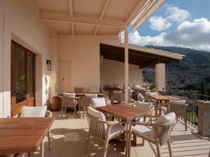 a patio with tables and chairs on a balcony at Es Petit de Valldemossa in Valldemossa