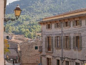 an old building with a street light in front of a mountain at Es Petit de Valldemossa in Valldemossa
