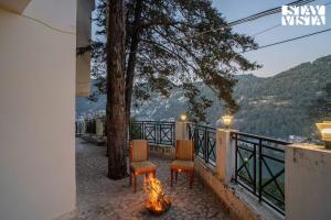 a patio with two chairs and a fire pit at StayVista at The Northern Lake House with Balcony in Nainital