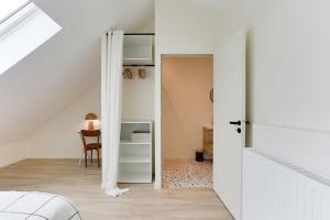 an attic bedroom with a white door and a table at Maison Joseph - Suite 2 in Saint-Jacques-de-la-Lande