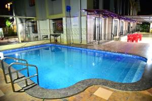 a large swimming pool with blue water at Aroma Villas in Lonavala +43 photos