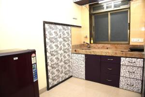 a kitchen with a sink and a shower backdoor at Aroma Villas in Lonavala