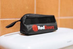 a red door bag sitting on top of a toilet at RGL Condotel Socorro by RedDoorz in Casiligan