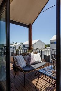 a chair on a deck with a view of a balcony at Champagne Skies - In Town Upstairs Apartment in Margaret River Town