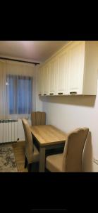 a kitchen with a table and chairs and white cabinets at Colibri Rezident! in Galaţi