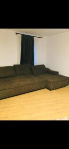 a brown couch in a room with a wooden floor at Colibri Rezident! in Galaţi