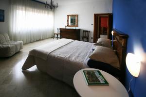 a bedroom with a large bed with a table and a table sidx sidx at Smile House in Matera