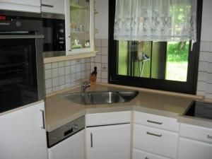 une cuisine avec un évier et une fenêtre dans l'établissement Ferienhaus Nr 74, Kategorie Komfort L m Sauna, behindertenfreundlich, Feriendorf Hochbergle, Allgäu, à Bichel