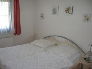 - un lit blanc dans une chambre avec fenêtre dans l'établissement Ferienhaus Nr 74, Kategorie Komfort L m Sauna, behindertenfreundlich, Feriendorf Hochbergle, Allgäu, à Bichel